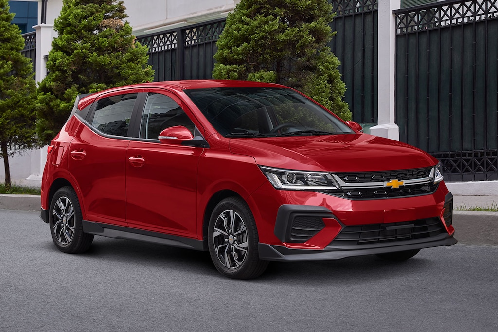 Vista delantera lateral de Chevrolet Aveo HB 2025, con faros de halógeno proyector y LED diurnas con direccional integrada